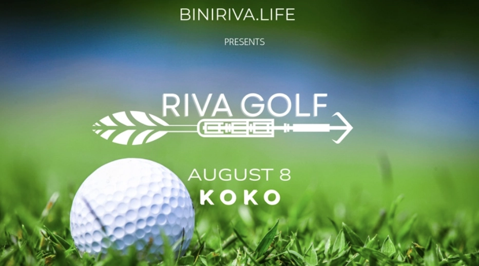 Close-up of a golf ball nestled in lush green grass with soft blue sky behind